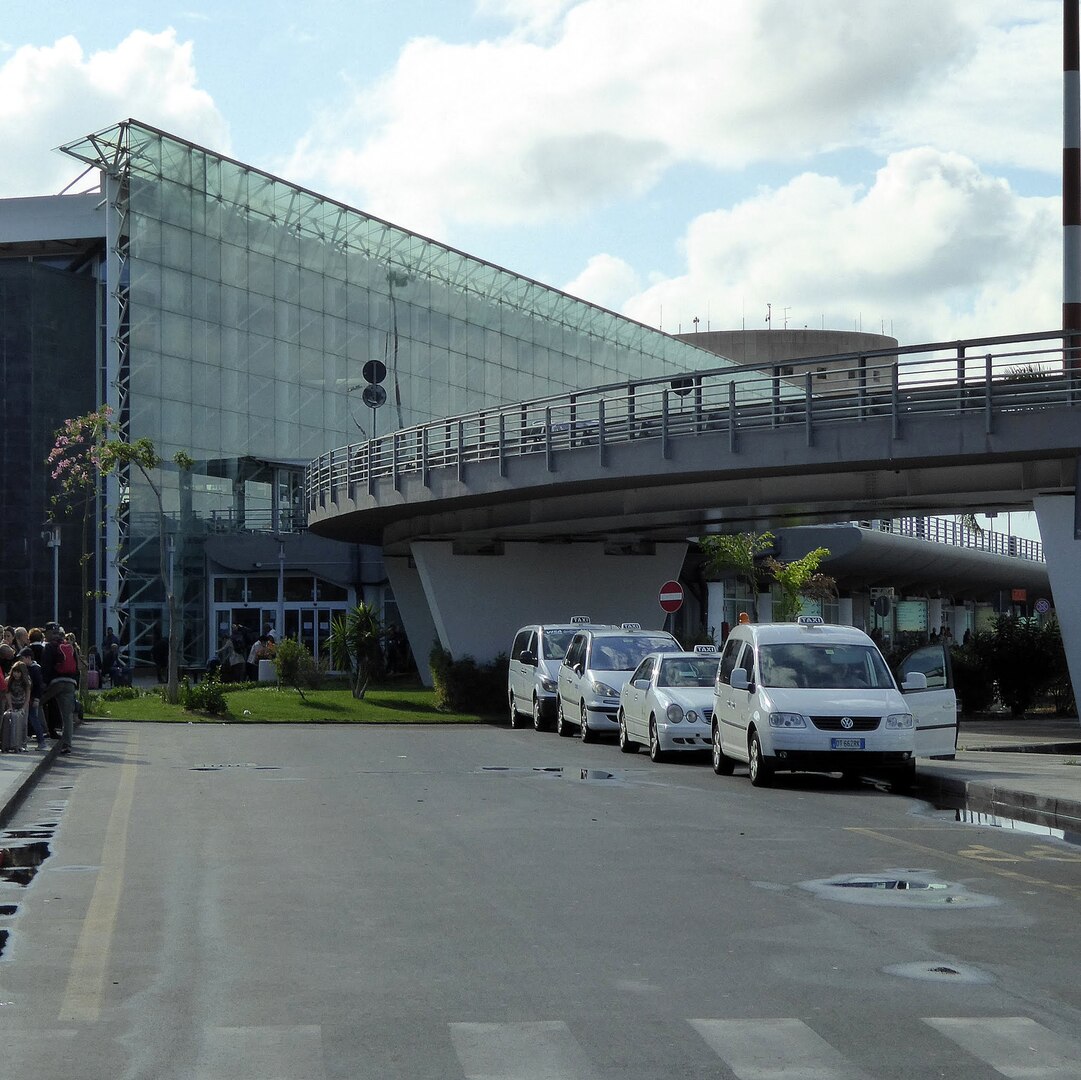 Shuttle van and passengers outside Catania Airport heading toward Mount Etna and Sicilian coastal towns